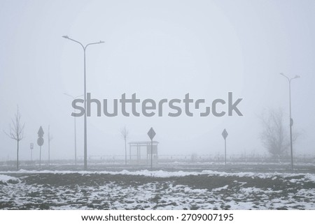 Empty public bus stop in the thick milky fog. Liminal spaces