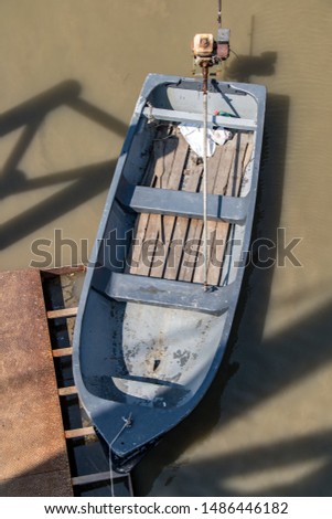 A empty punt tied at the river bank, top view.