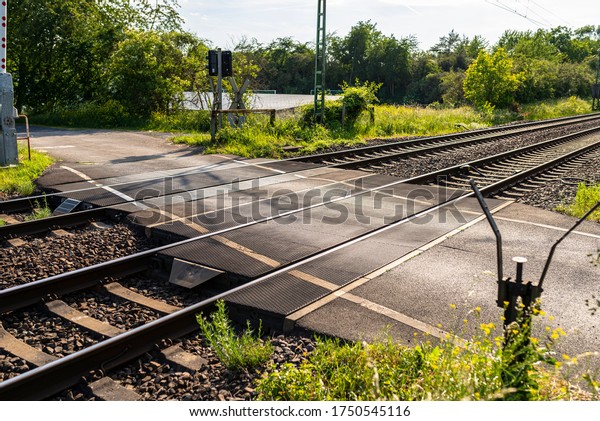 Empty railroad crossing in the countryside, on
the road with open
barriers.