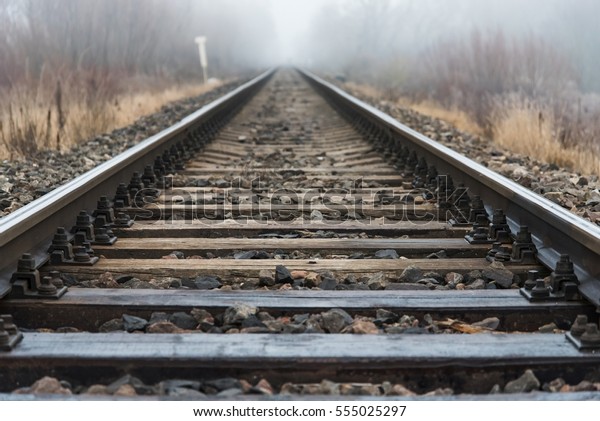 Empty Railroad Track Going Into Fog - Stock Photo