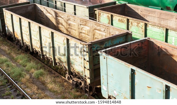 Empty railway cars for various crumbly\
cargoes. Railway cars. Top view. Commodity cars on rails. Lot of\
empty old rusty railway cars. The train\
path