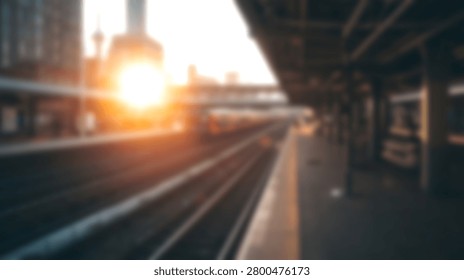Empty railway platform and multiple tracks leading towards a city skyline during a golden sunset