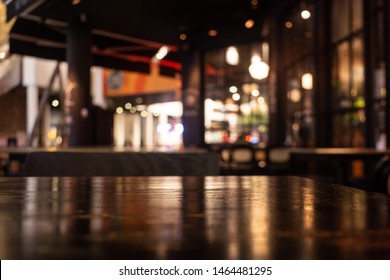 Empty Real Wood Table Top With Light Reflection On Scene At Restaurant, Pub Or Bar At Night. Blurred Background For Product Display Or Montage Your Products With Several Concept Idea And Any Occasion.