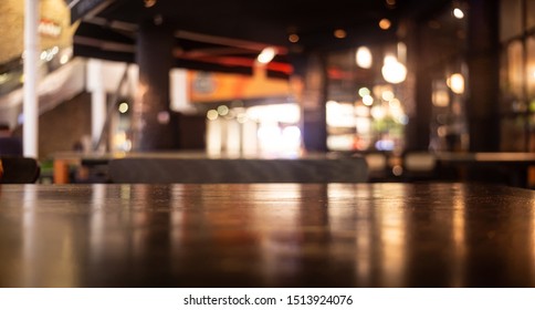 Empty Real Wood Table Top With Light Reflection On Scene At Restaurant, Pub Or Bar At Night. Blurred Background For Product Display Or Montage Your Products With Several Concept Idea And Any Occasion.