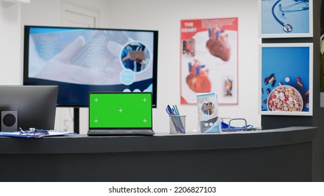 Empty Reception Desk With Greenscreen On Laptop Display, Hospital Lobby Counter. Computer With Blank Chroma Key Screen, Isolated Mockup Template And Copyspace Background Display.