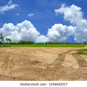 Empty Reclamation Area, Vacant Compact Soil Of Construction Site With Car Tire Printed And Beautiful Landscape View And Blue Sky. Land Plot For Sales And Real Estate Development Sale Project Concept