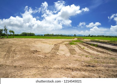 Empty Reclamation Area, Vacant Compact Soil Of Construction Site With Car Tire Printed And Beautiful Landscape View And Blue Sky. Land Plot For Sales And Real Estate Development Sale Project Concept