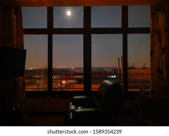 Empty Recliner Chair In Front Of Tv During Full Moon By The Big Window. 