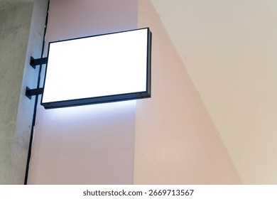 Empty rectangular lightbox signage mounted on wall with illumination, ready for advertisement, branding, marketing, commercial promotion, business information, modern minimal interior design concept.