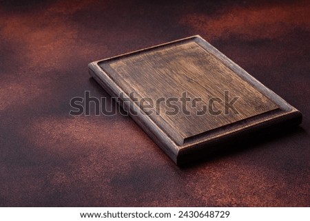 Empty rectangular wooden cutting board on textured concrete background. Cooking at home