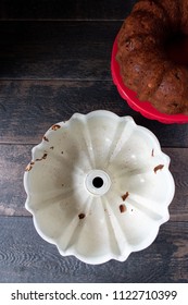 Empty Red Bundt Pan With Baked Carrot Cake Beside It On Farmhouse Table Top View