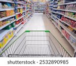 Empty red shopping cart view with warm light, Shopping cart in supermarket, Trolley in department store Abstract blurred of colorful shelves.