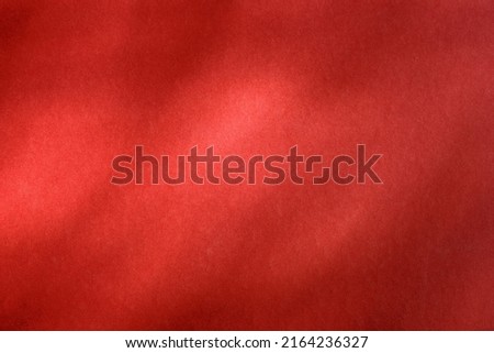 Empty red textured wall close up with shadows. Sparse texture and background