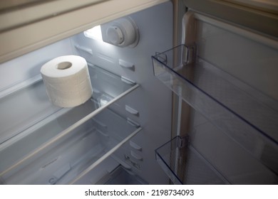 Empty Refrigerator. Toilet Paper in an Empty Refrigerator. White Open Refrigerator. The Concept of a Diet for Weight Loss.