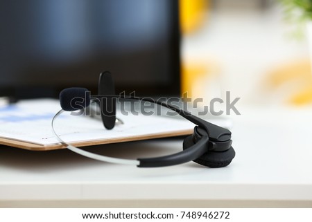 Empty remote office workplace with laptop pc and headset closeup. Receptionist or secretary of contact data center desktop keyboard device desk table ip telephony or callcenter voice message system
