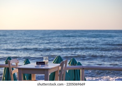 Empty reserved table at a greek taverna and the sea in background in Chania Crete - Greece 