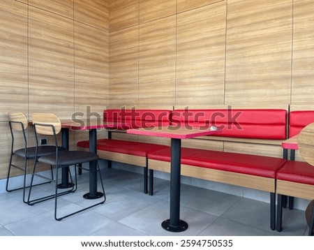 Empty restaurant interior with red chairs and wooden wall stage waiting for customers.