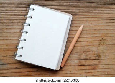 An empty retro notebook with old paper and little pencil - Powered by Shutterstock