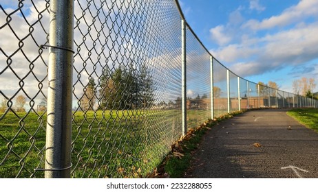 Empty road beside mesh fence in elementary school area, wide angle