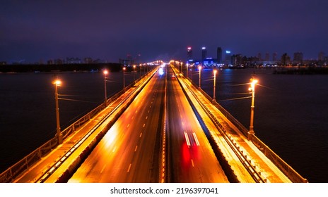 Empty road bridge across the river, night cityscape. There is no traffic.