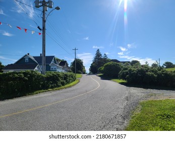 An Empty Road Heading Through A Quiet Neighborhood. 