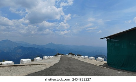 Empty Road with Mountains and Cloudy Sky