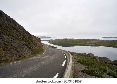 An empty road in Nordkapp, Norway under a cloudy sky