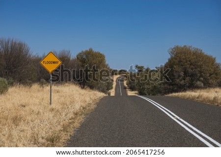 An empty road with a sign 