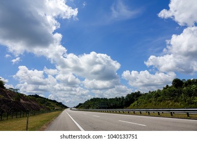 Empty road under blue sky with clouds at highway.