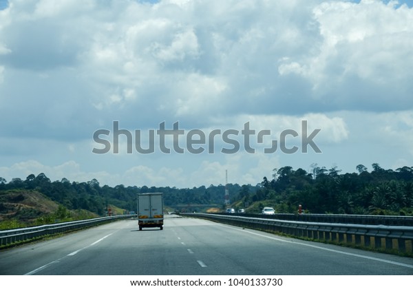 Empty road\
under blue sky with clouds at\
highway.