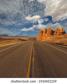 Empty Road Under A Cloudy Blue Sky In Arizona Desert. US Southwest Scenery.