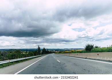 An empty road under a cloudy sky