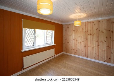 Empty Room Being Decorated With Wooden Panelling, And An Orange Feature Wall.  Ideal For Bedroom, Or Study With Wooden Laminate Floors