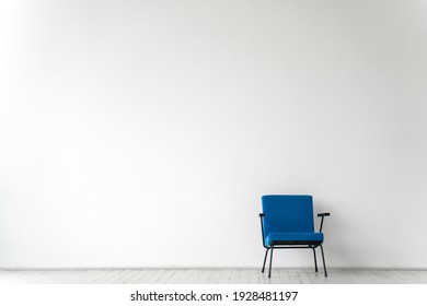 Empty Room With A Blue Chair On A White Wall Background