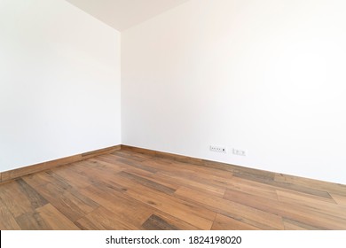 Empty Room With Dark Wooden Floating Laminate Flooring. House Interior, Wide Bedroom Or Living Room Space. Newly Recently Painted New Apartment Or House. Wood Floor.Real Estate, Property Management.