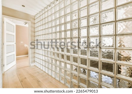an empty room with lots of glass blocks on the wall and wood flooring in front of the window panes