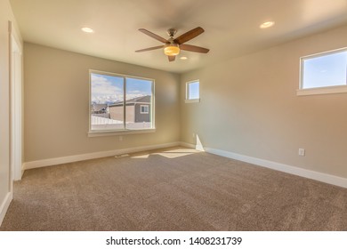 Empty room of a new house with beige wall paint and carpeted floor - Shutterstock ID 1408231739