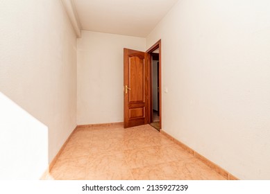 Empty Room With Orange Stoneware Floor, Mahogany Wood Door And White Painted Walls And Brass Door Handle