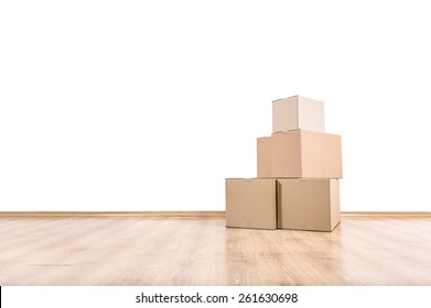 Empty room with a white wall and moving boxes on the floor.