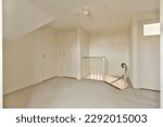 an empty room with white walls and carpet on the floor, there is a staircase leading up to the second floor
