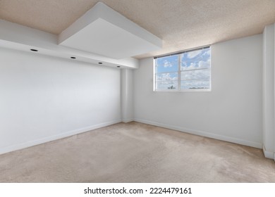 Empty room with window with sky in the background, white walls, carpeted floor and beige ceiling, wall with 4 lights, ideal shot for office or bedroom rendering