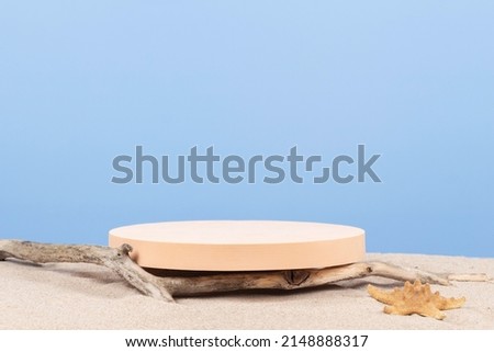 Empty round beige platform podium and dry tree twigs on white beach sand background. Minimal creative composition background for cosmetics or products presentation. Front view