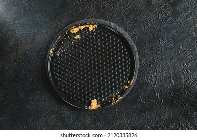 Empty Round Black Baking Dish With Pie Crumbs On A Black And Blue Concrete Background. Top View, Flat Lay With Copy Space