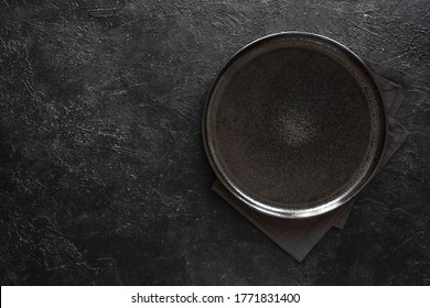 Empty round black plate on dark black background, top view, copy space. Ceramic black platter on stone table, mockup. - Shutterstock ID 1771831400