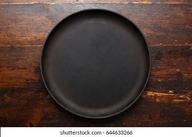 Empty Round Cast-iron Pan For Pizza On A Brown Wooden Background, Place For Text