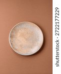 An empty round ceramic plate on a table, kitchenware. An empty plate as a food background for your design