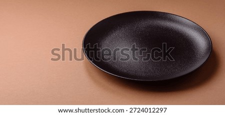 An empty round ceramic plate on a table, kitchenware. An empty plate as a food background for your design