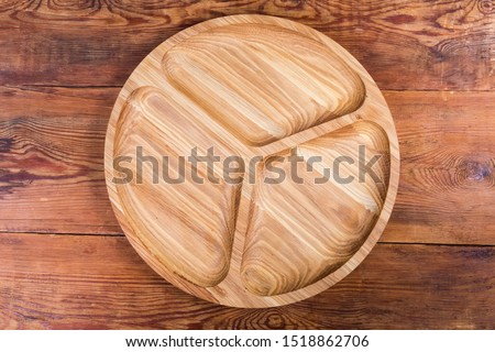 Empty round compartmental dish with three departments, made with oak wood on the old rustic table, top view
 Stock photo © 