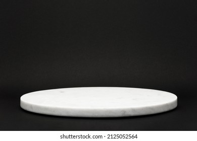 empty round marble tray on black background for presentation of various products, stone podium concept