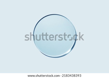 Empty round petri dish or glass slide on blue background. Mockup for cosmetic or scientific product sample